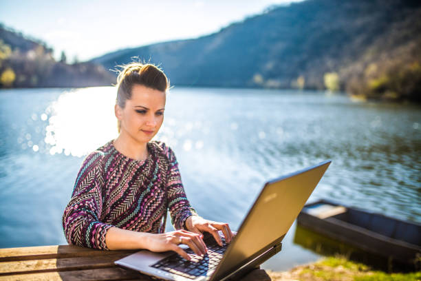 istock Working on the laptop by lake 1141733034