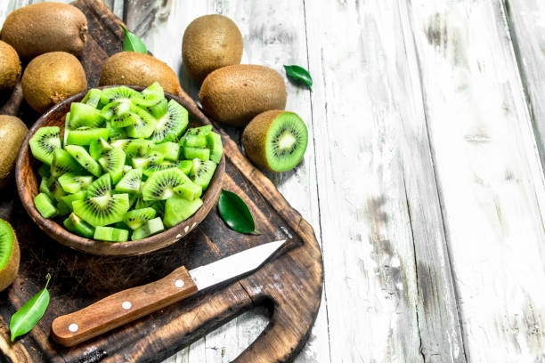 istock Kiwi slices in a bowl on a cutting Board with a knife. 1141733063
