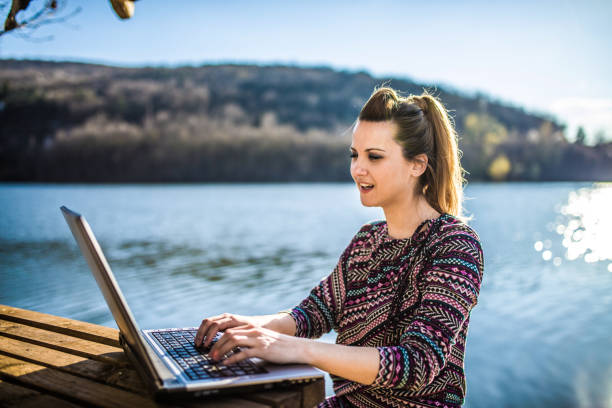 istock Working on the laptop by lake 1141733081