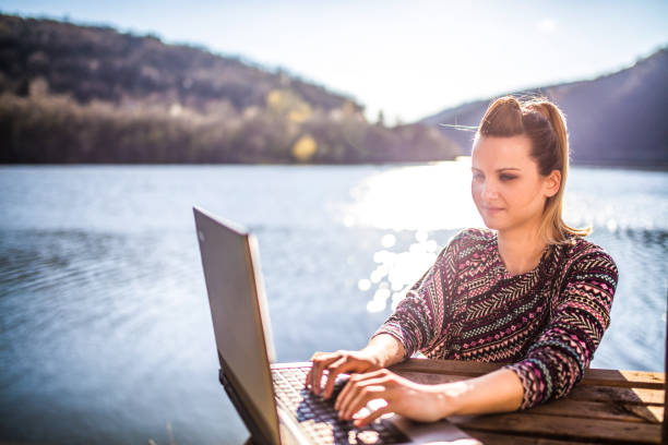 istock Working on the laptop by lake 1141733118