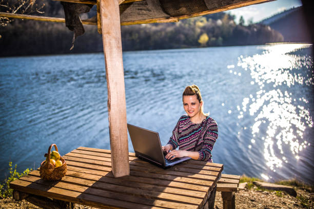 istock Working on the laptop by lake 1141733121