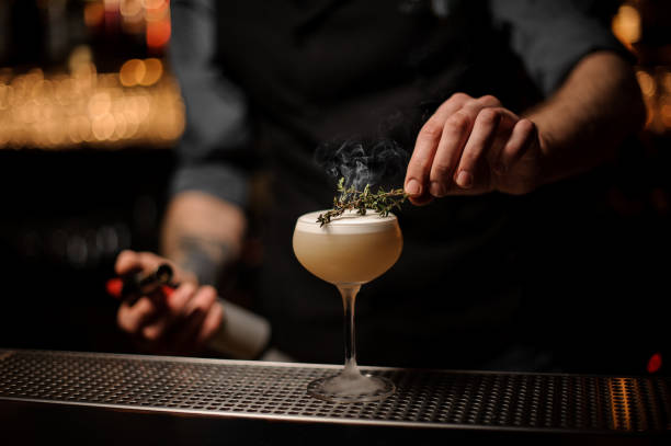 istock Bartender adds rosemary in alcohol light brown cocktail 1141733339