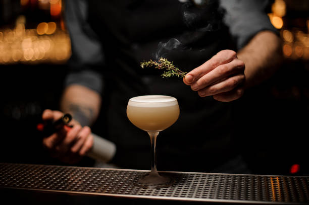 istock Bartender adds rosemary in alcohol light brown cocktail 1141733392