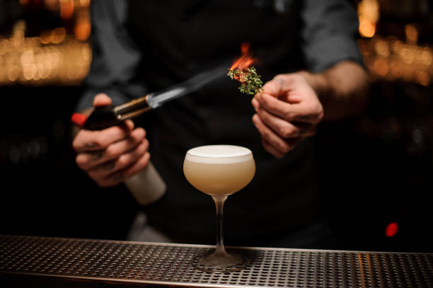 istock Bartender adds rosemary in alcohol light brown cocktail 1141733446