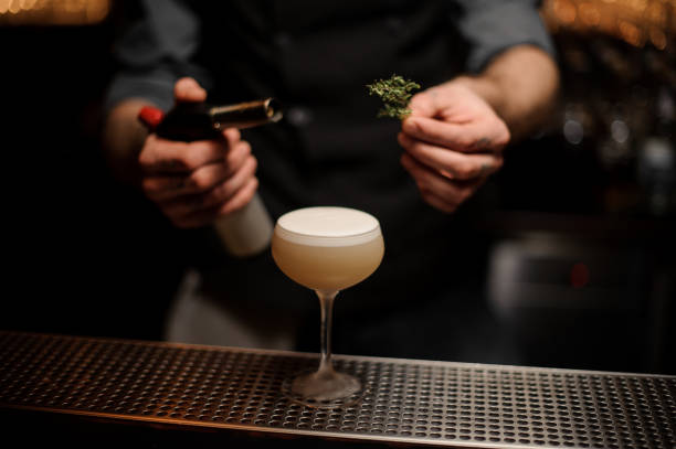 istock Bartender adds rosemary in alcohol light brown cocktail 1141733463