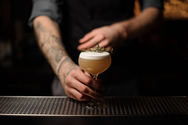 istock Bartender serving a cocktail in the glass decorated with a smoked herb 1141735509