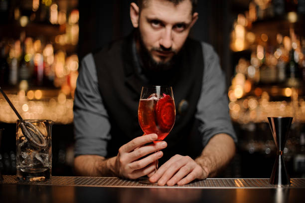istock Bartender serving a delicious cocktail with a decor of red slice 1141735583
