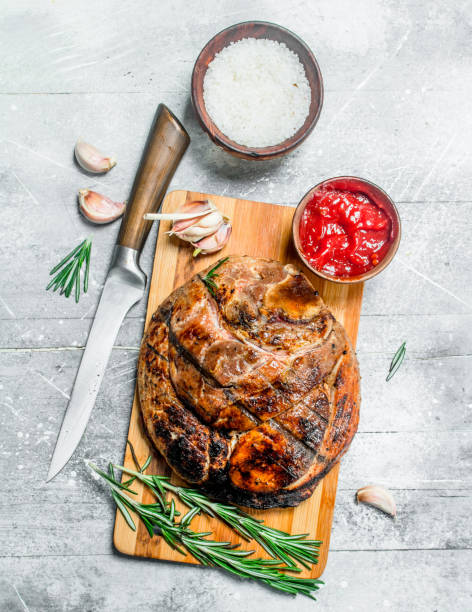 istock Big grilled pork steak with spices and herbs. 1141735682