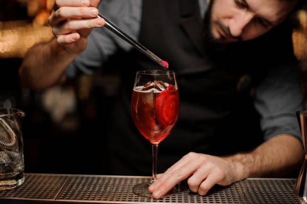 istock Male bartender pouring red cocktail in glass 1141737167