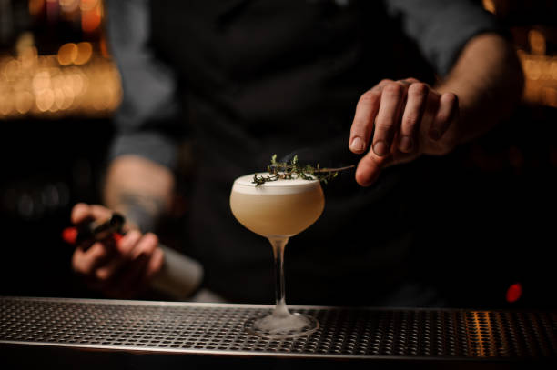 istock Professional bartender adding to a cocktail glass smoked herb 1141737201