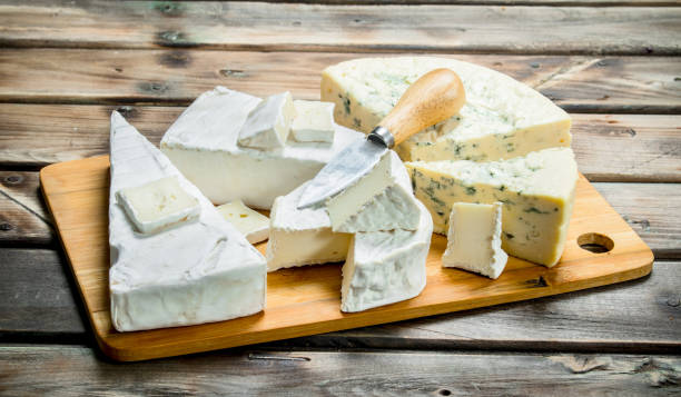 istock Blue and brie cheese on a chopping Board with a knife. 1141737224