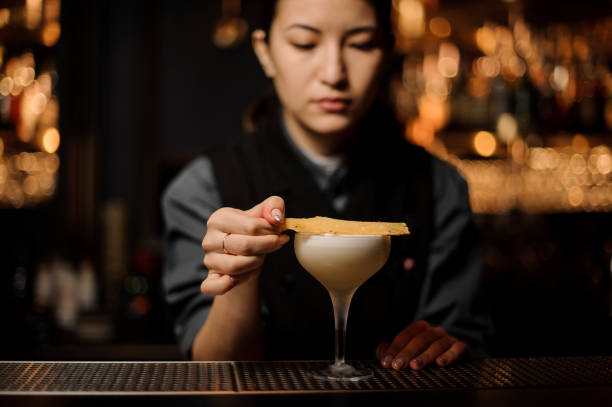 istock Professional bartender girl adding to a delicious cocktail dried fruit decor 1141737443