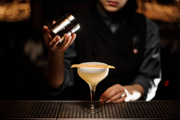 istock Professional bartender girl holding a spice shaker adding to a delicious cocktail 1141737468
