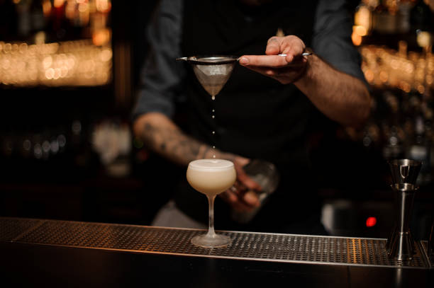 istock Professional bartender pouring a delicious cocktail through the sieve 1141737657