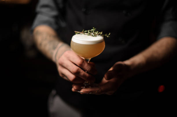 istock Professional bartender serving a cocktail in the glass decorated with a smoked herb 1141737685