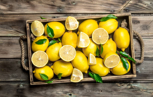 istock Juicy lemons with leaves in tray. 1141737700