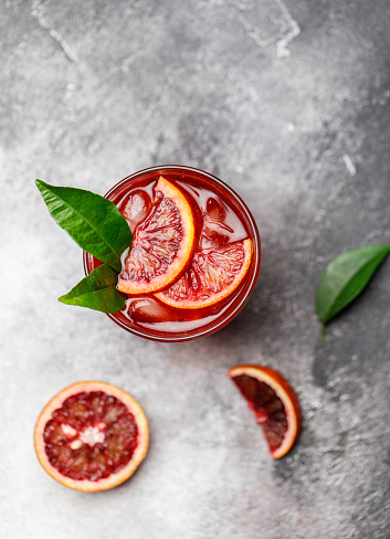 Blood orange juice with ice and orange slice. Fresh summer cocktail with red oranges in a glass. Fresh cocktail. Nonalcoholic blood orange cocktail in a glass