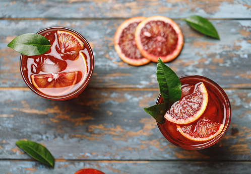 Blood orange juice with ice and orange slice. Fresh summer cocktail with red oranges in a glass. Fresh cocktail. Nonalcoholic blood orange cocktail in a glass.