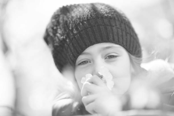 istock Little girl sniffs a flower in nature 1141741305
