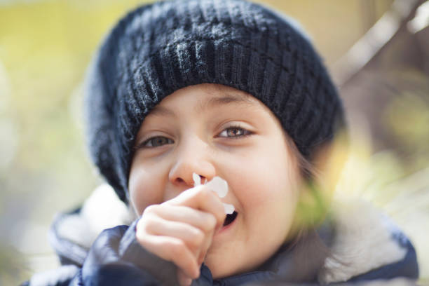 istock Little girl sniffs a flower in nature 1141741391