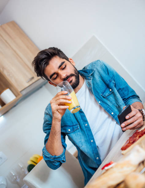 istock Happy man text messaging on cell phone during breakfast time 1141741442