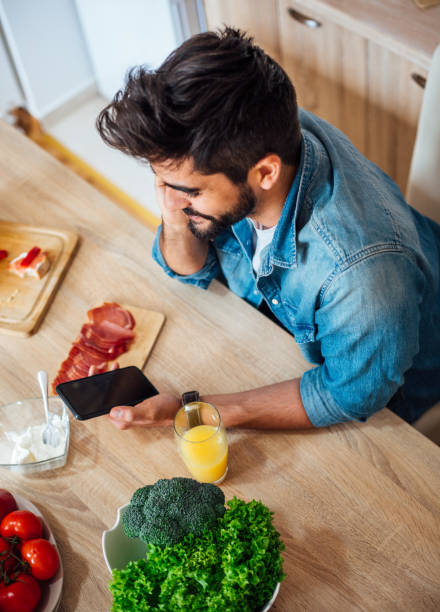 istock Happy man text messaging on cell phone during breakfast time 1141741556