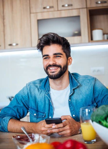 istock Happy man text messaging on cell phone during breakfast time 1141741614