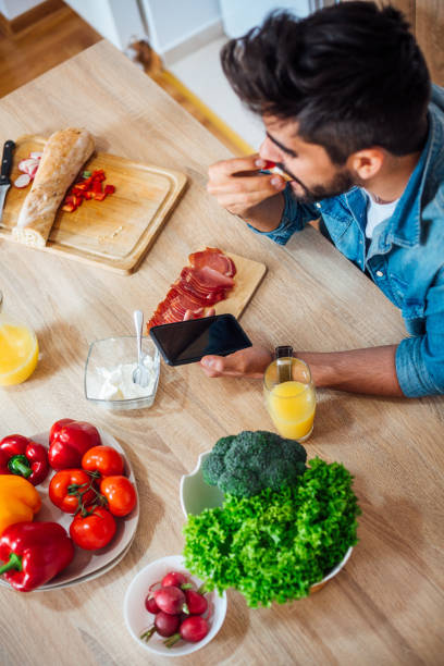 istock Happy man text messaging on cell phone during breakfast time 1141741671