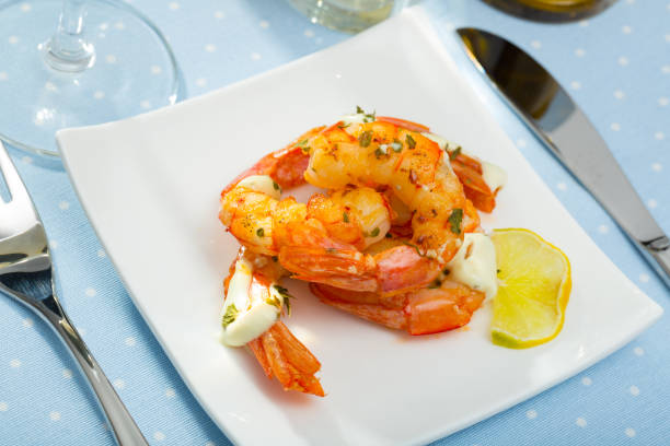 istock Split fried prawns with lemon and parsley on a white plate 1141743199