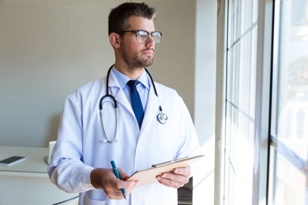 istock Confident male doctor looking sideways in the office. 1141743938