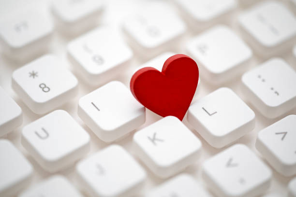 Small red heart on computer keyboard. Internet dating concept. stock photo