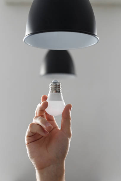 istock Changing the bulb for led bulb in floor lamp in black colour. On light gray background 1141746544