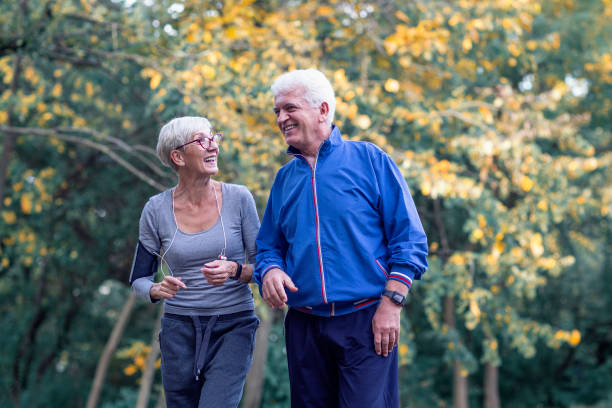 istock Two aged couple jogging in park 1141746813