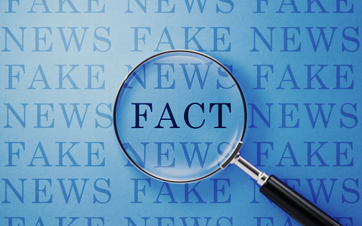 Noticias falsas y concepto de hechos-lupa y texto de noticias falsas sobre fondo azul photo