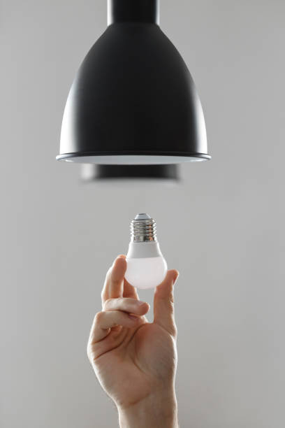 istock Changing the bulb for led bulb in floor lamp in black colour. On light gray background. 1141746954