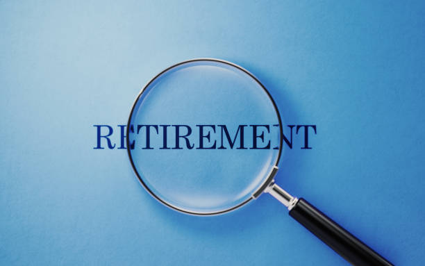 istock Retirement Concept - Magnifier And Retirement Text On Blue Background 1141748127
