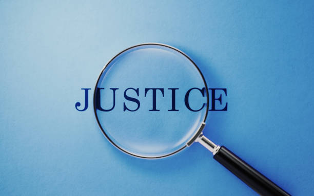 istock Justice Concept - Magnifier And Justice Text On Blue Background 1141748627