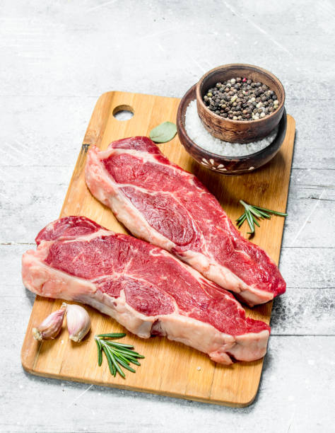 istock Raw beef steaks with spices and herbs. 1141753356