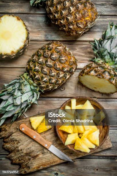 Sliced Pineapple In A Bowl On A Cutting Board With A Knife And A Whole  Pineapple Stock Photo - Download Image Now - iStock