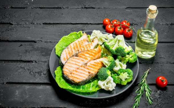 istock Grilled salmon steaks with tomatoes and broccoli in a plate. 1141755545