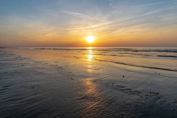 istock orabge colored sunset over calm sea beach water fields 1141755658