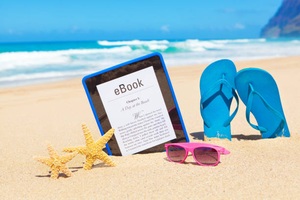 american summer reading novel na e-reader cyfrowy tablet na plaży - kindle e reader book reading zdjęcia i obrazy z banku zdjęć