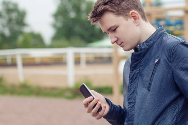 Teen holding mobile (cell) phone in hand
