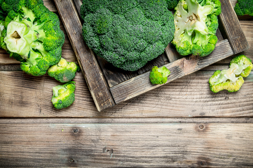Fresh broccoli in a wooden box. On a wooden background.