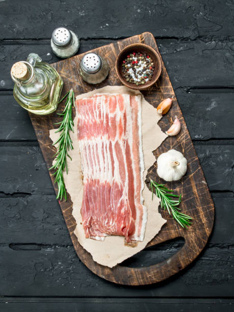 istock Raw bacon with rosemary and spices. 1141757699