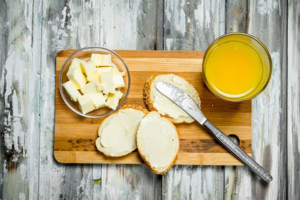 Fresh bread with butter and orange juice .