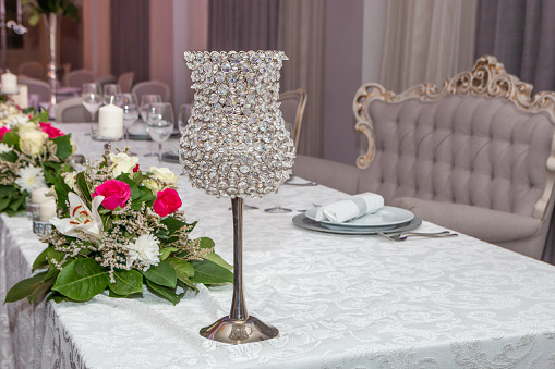 Decorative luxury crystal lamp. Decoration details on wedding table in restaurant. Close up.