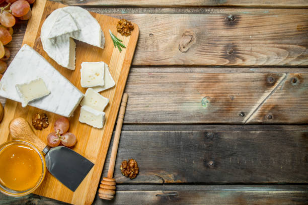 istock Brie cheese with grapes, nuts and honey on the Board. 1141758522