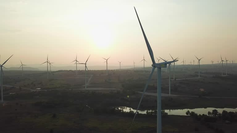 Windenergieanlagen bei Sonnenuntergang, die erneuerbare Energien produzieren