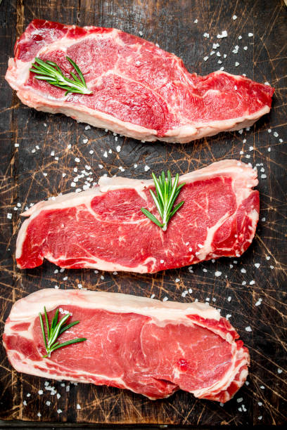 istock Raw marbled beef steaks with salt and aromatic spices. 1141759277